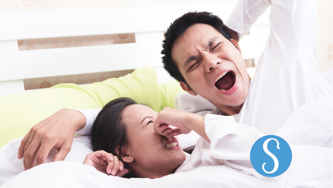 A woman holding her nose closed because of her partners bad morning breath