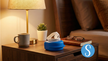 A Somnofit-S anti-snoring mouth guard sits on a night stand.