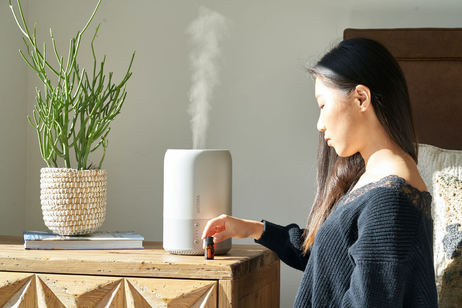 Woman putting essential oils into humidifier