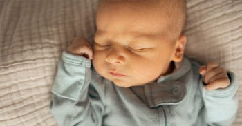 Sleeping baby with hand next to cheek