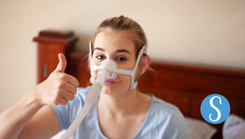 A woman wearing a CPAP device.