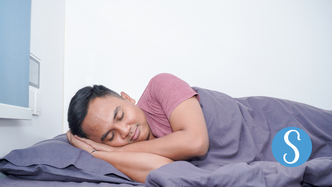 A man sleeping peacefully on his side.