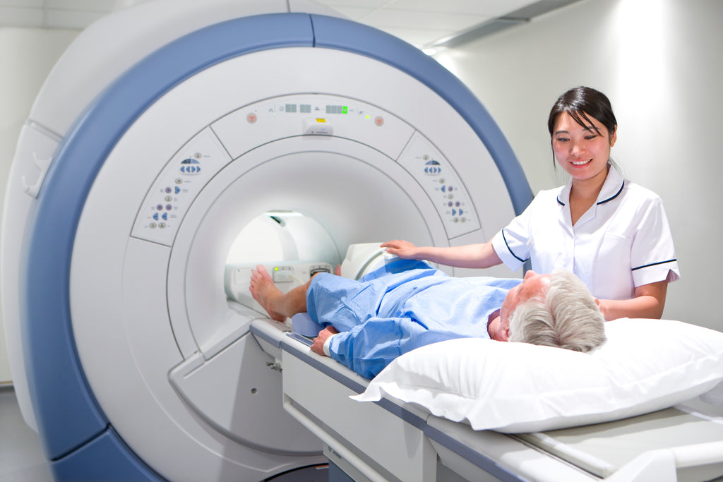 female radiologist assisting older man into MRI machine