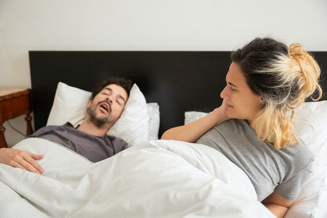 why do I snore so loud? man and woman in bed