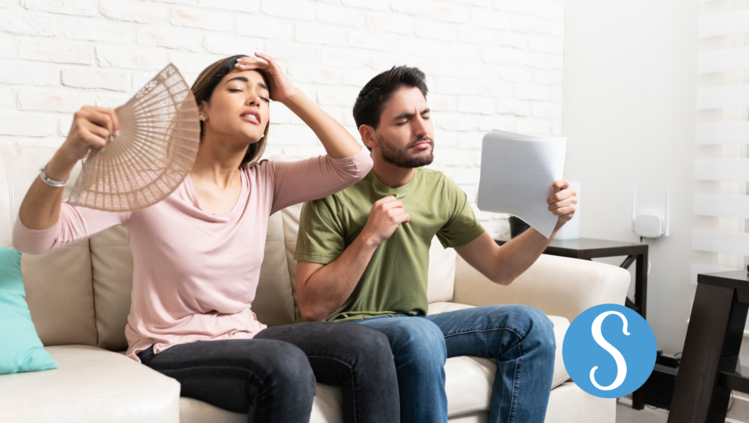A man and woman trying to cool themselves down.
