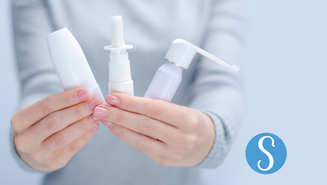 A woman holding several nose sprays