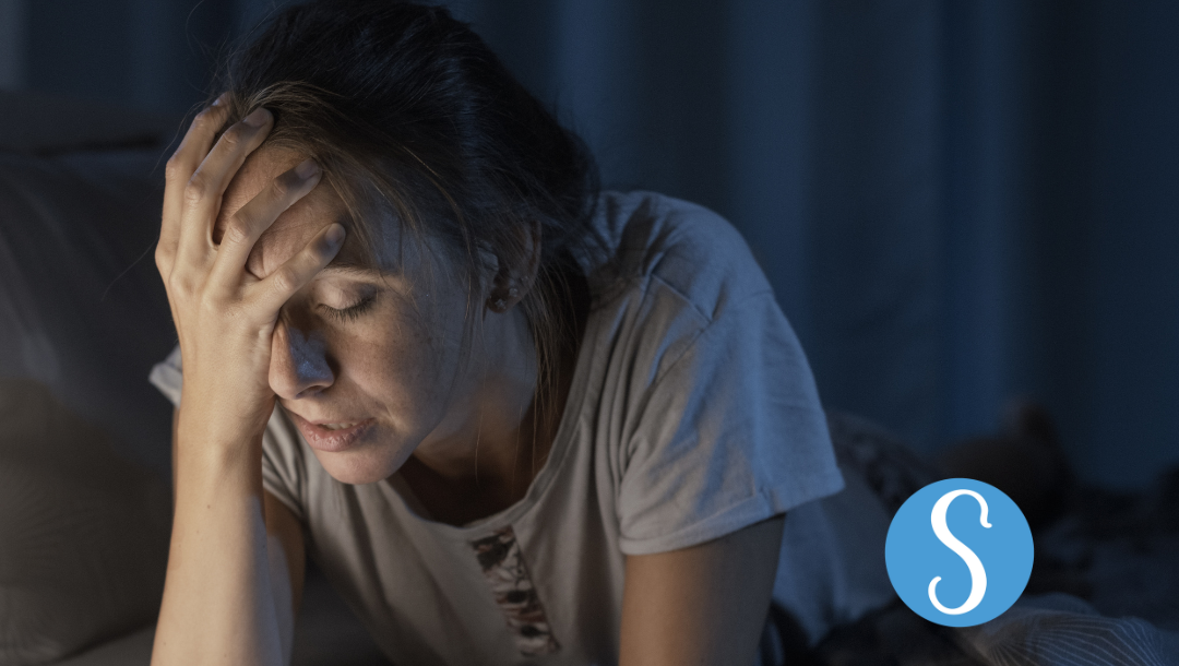 A woman frustrated that she can't sleep.