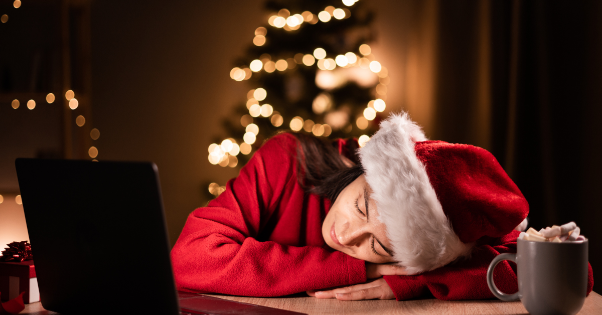 Woman in Christmas attire sleeping at desk